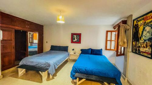 Duas camas num quarto com lençóis azuis em Casa Nazimova Blue Room em San Cristóbal de Las Casas