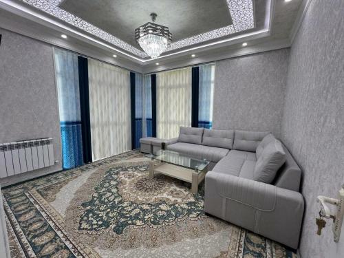 een woonkamer met een bank en een tafel bij Comfort House in Tasjkent