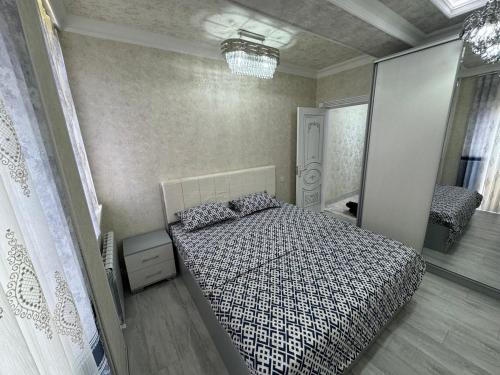 een slaapkamer met een bed en een spiegel bij Comfort House in Tasjkent