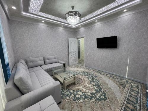 een woonkamer met een bank en een tv bij Comfort House in Tasjkent