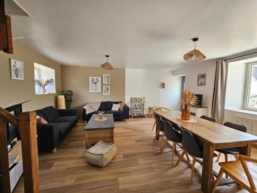 un salon avec une table et un canapé dans l'établissement L'escapade, maison de campagne, à Étienville
