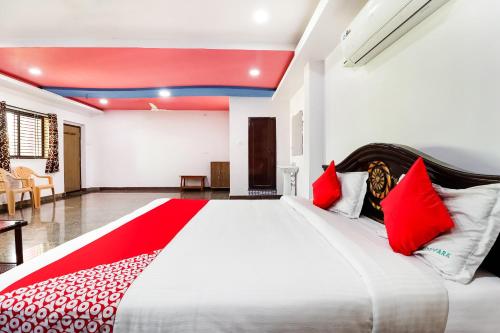 a bedroom with a large bed with red pillows at Collection O 67511 Golden Park in Proddatūr