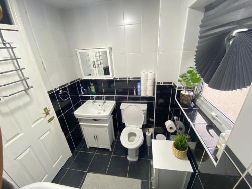 a small bathroom with a toilet and a sink at Lovely 3 bedroom house near city centre - Basildon in Basildon