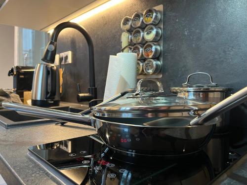 a pots and pans on a stove in a kitchen at BEYOND Staying Apartments Passau in Passau