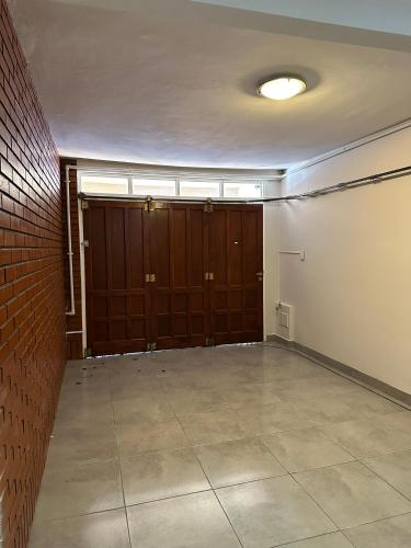 an empty room with brown doors and a brick wall at Casa Aurora in Olavarría