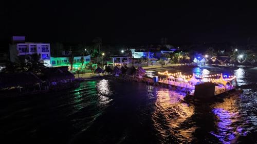 a boat with lights on the water at night at Hotel La Fragata in Coveñas