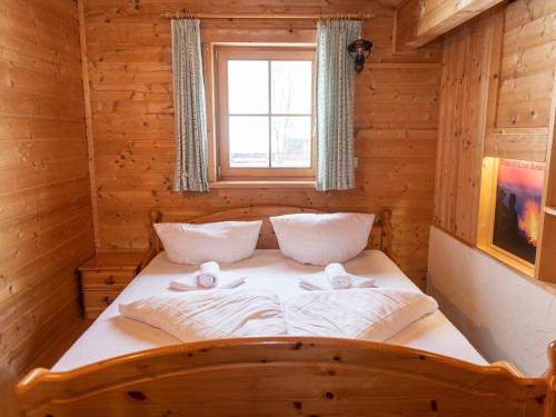 een bed in een houten kamer met een raam bij Urige Doppelhaushälfte 4 rechts in Grafenweg
