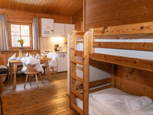 Zimmer mit 2 Etagenbetten und einem Esszimmer in der Unterkunft Uriges Chalet 1 in Grafenweg