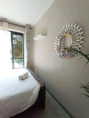 sypialnia z łóżkiem i lustrem na ścianie w obiekcie Kerugoya suits w mieście Keruguya