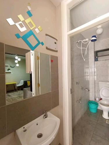 W łazience znajduje się umywalka, toaleta i lustro. w obiekcie Kerugoya suits w mieście Keruguya