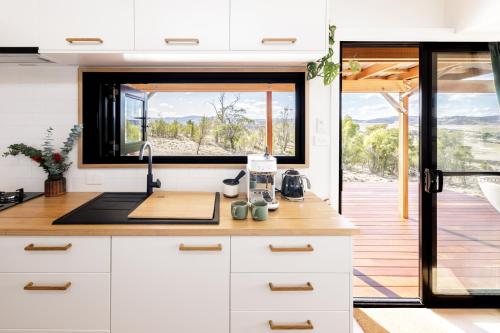 a kitchen with a counter with a sink and a window at Daisy Bank Cottages in Richmond