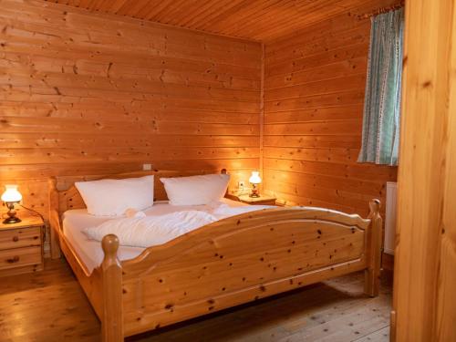 ein Schlafzimmer mit einem Bett in einem Holzzimmer in der Unterkunft Urige Doppelhaushälfte 6 und 7 in Grafenweg