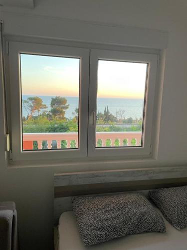 2 ventanas en un dormitorio con vistas al océano en Benelux Apartments en Brca