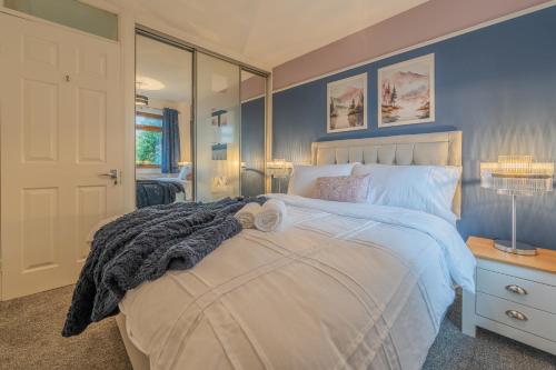 ein Schlafzimmer mit einem großen Bett mit blauen Wänden in der Unterkunft A Cosy Home from Home in Middleton
