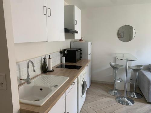 une petite cuisine avec un évier et un réfrigérateur dans l'établissement Charmant Appartement à 5 minutes de la plage, à Nice