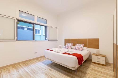 een witte slaapkamer met een groot bed en ramen bij Padilla 56 in Las Palmas de Gran Canaria