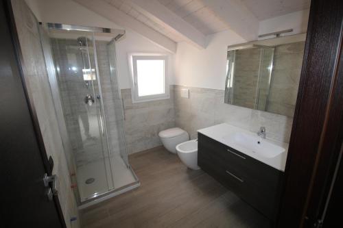 uma casa de banho com um chuveiro, um lavatório e um WC. em Appartamenti Colombo em Arma di Taggia