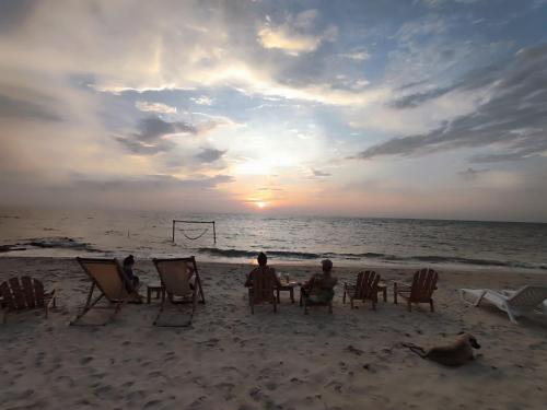a group of people sitting at a table on the beach at Palenque Beach House in San Onofre