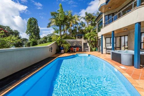 a swimming pool in the backyard of a house at Beachside Bliss Castor Bay - Holiday by the Beach in Auckland
