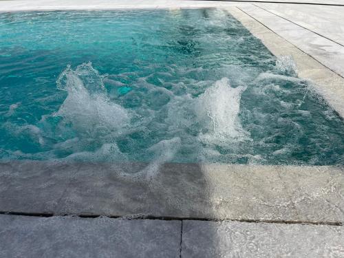 a pool of water with a splash in the water at First Eco-Villa in Polis Chrysochous