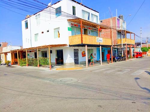 una calle vacía con un edificio blanco en la esquina en HOSPEDAJE WELCOME paracas en Paracas