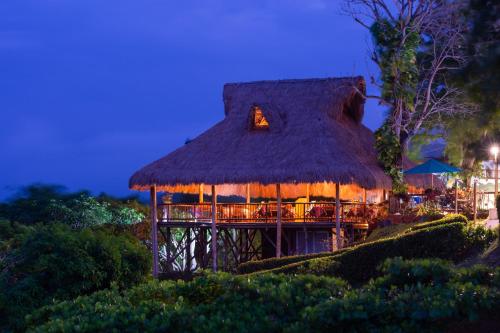 a hut with a thatched roof at night at Aite Eco Resort in Palomino
