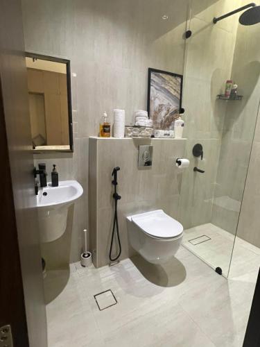 a bathroom with a toilet and a sink and a shower at شقة فاخرة بمدخل طراز سلماني in Riyadh