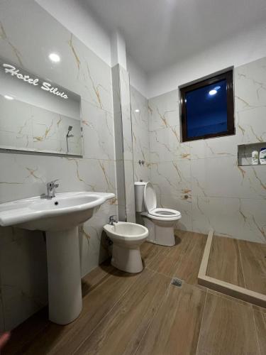 a bathroom with a sink and a toilet at Hotel Silvio in Fier
