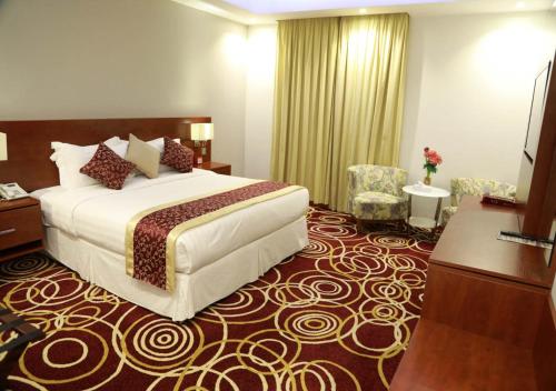 a hotel room with a bed and two chairs at Wow Hotel Jeddah in Jeddah