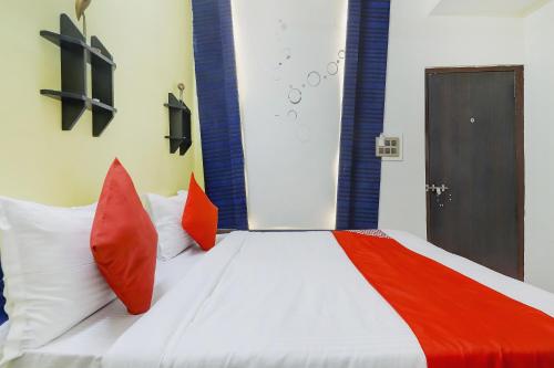 a bedroom with a bed with red and white pillows at Super OYO Flagship Relax Grand Near Snow World in Hyderabad