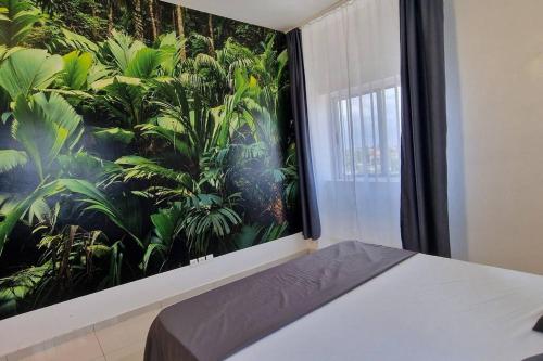 1 dormitorio con una gran pintura en la pared en Jungle Sensation, en Lomé