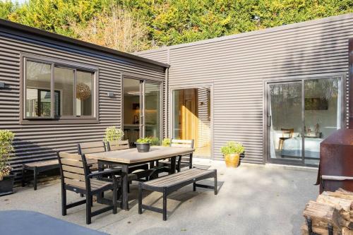 a patio with a table and chairs and a building at 5 o'clock Somewhere in Masterton