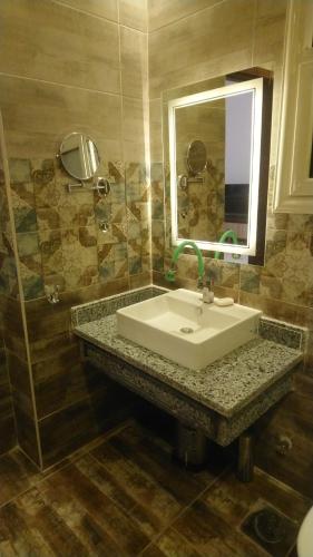 a bathroom with a sink and a mirror at Apartments Next to Mivida in New cairo