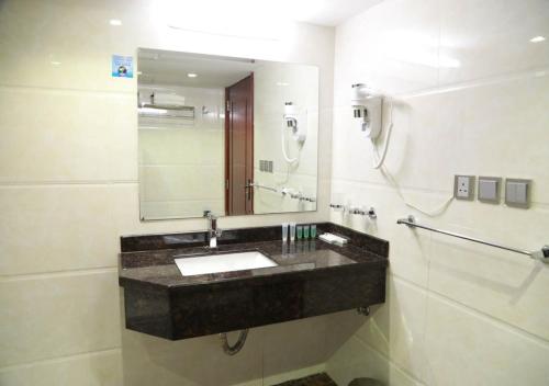 baño con lavabo y espejo grande en Wow Hotel Jeddah en Yeda