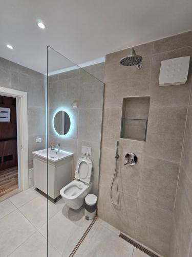 a bathroom with a shower with a toilet and a sink at Luxury Studio Apartment Square 21, Seven Heavens in Tirana
