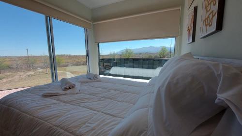 uma cama grande num quarto com uma janela grande em Son Del Viento em La Cumbre
