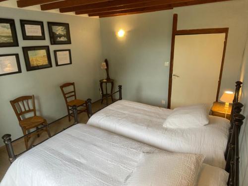 two beds in a bedroom with two chairs at Gîte chaleureux avec jardin arboré, terrasse, salle de jeux et parking privé à Pré-Saint-Évroult. - FR-1-581-3 in Pré-Saint-Évroult
