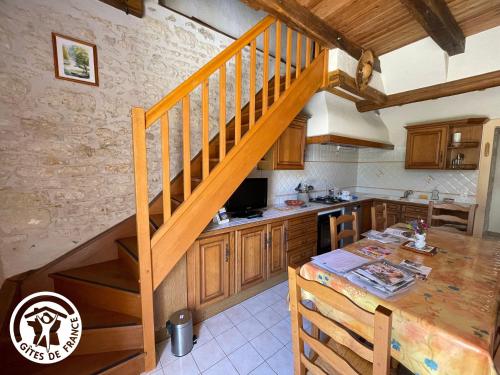 une cuisine avec un escalier en bois dans une maison dans l'établissement Maison au cœur du Marais Poitevin avec barques, canoës, pédalo et vélos включены - FR-1-426-147, à Damvix