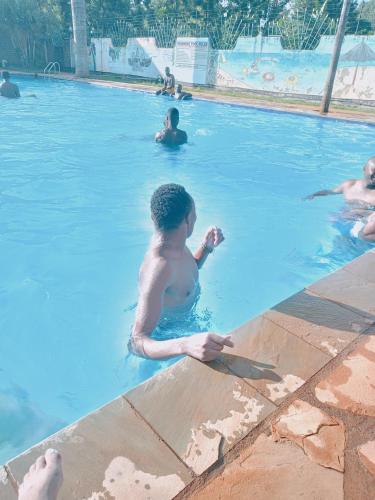 eine Gruppe von Personen in einem Schwimmbad in der Unterkunft Kerugoya suits in Keruguya