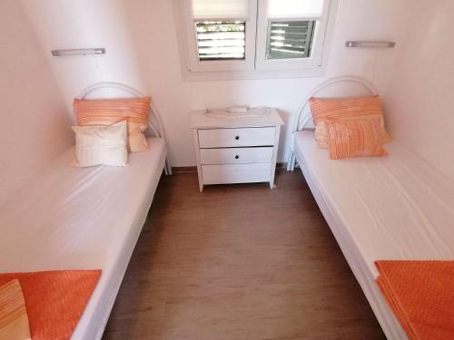 zwei Betten in einem kleinen Zimmer mit Fenster in der Unterkunft Seaside holiday house Sevid, Trogir - 23061 in Sevid