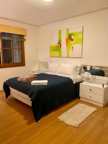 ein Schlafzimmer mit einem großen Bett und einem weißen Schrank in der Unterkunft Apartamento Lago Negro in Gramado