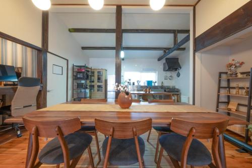 a dining room with a large wooden table and chairs at 古民家ワーケーション ふふ庵｜駅徒歩5分｜ゆる旅｜屋根在りBBQ施設｜テレワーク in Ōhara