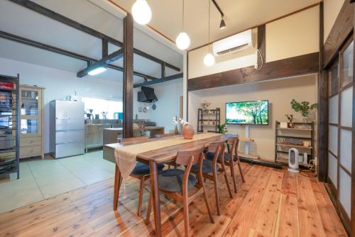 a large kitchen with a wooden table and chairs at 古民家ワーケーション ふふ庵｜駅徒歩5分｜ゆる旅｜屋根在りBBQ施設｜テレワーク in Ōhara