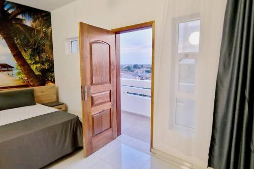 a bedroom with a door leading to a balcony at Palm Beach in Lomé