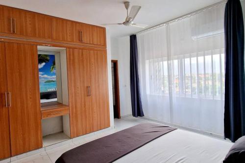 a bedroom with a tv and a large window at Palm Beach in Lomé