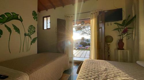 a bedroom with two beds and a view of a patio at La Cabaña Eco Hotel in Suaita