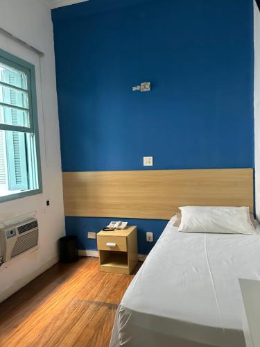a bedroom with a blue wall and a bed at Hotel Internacional São Paulo in Sao Paulo