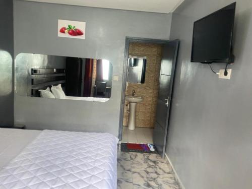 - une chambre avec un lit et une salle de bains avec un miroir dans l'établissement Sunrise Center Bonapriso 111, à Douala