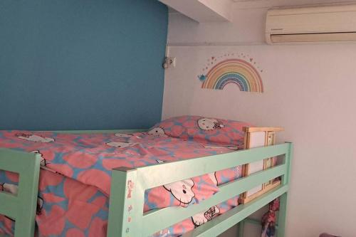 1 dormitorio con 1 cama con arco iris en la pared en Mendes Homestay - B&B In The Heart Of Praia Ext, en Praia