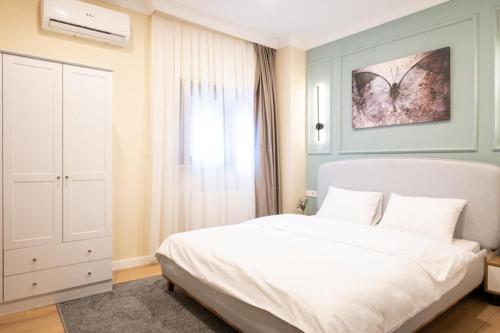 ein Schlafzimmer mit einem weißen Bett und einem Fenster in der Unterkunft Blue cistern Metin suites in Istanbul